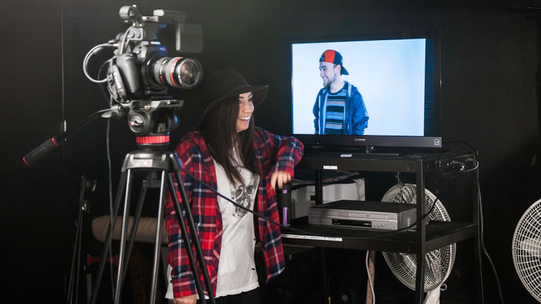A student filming in a studio