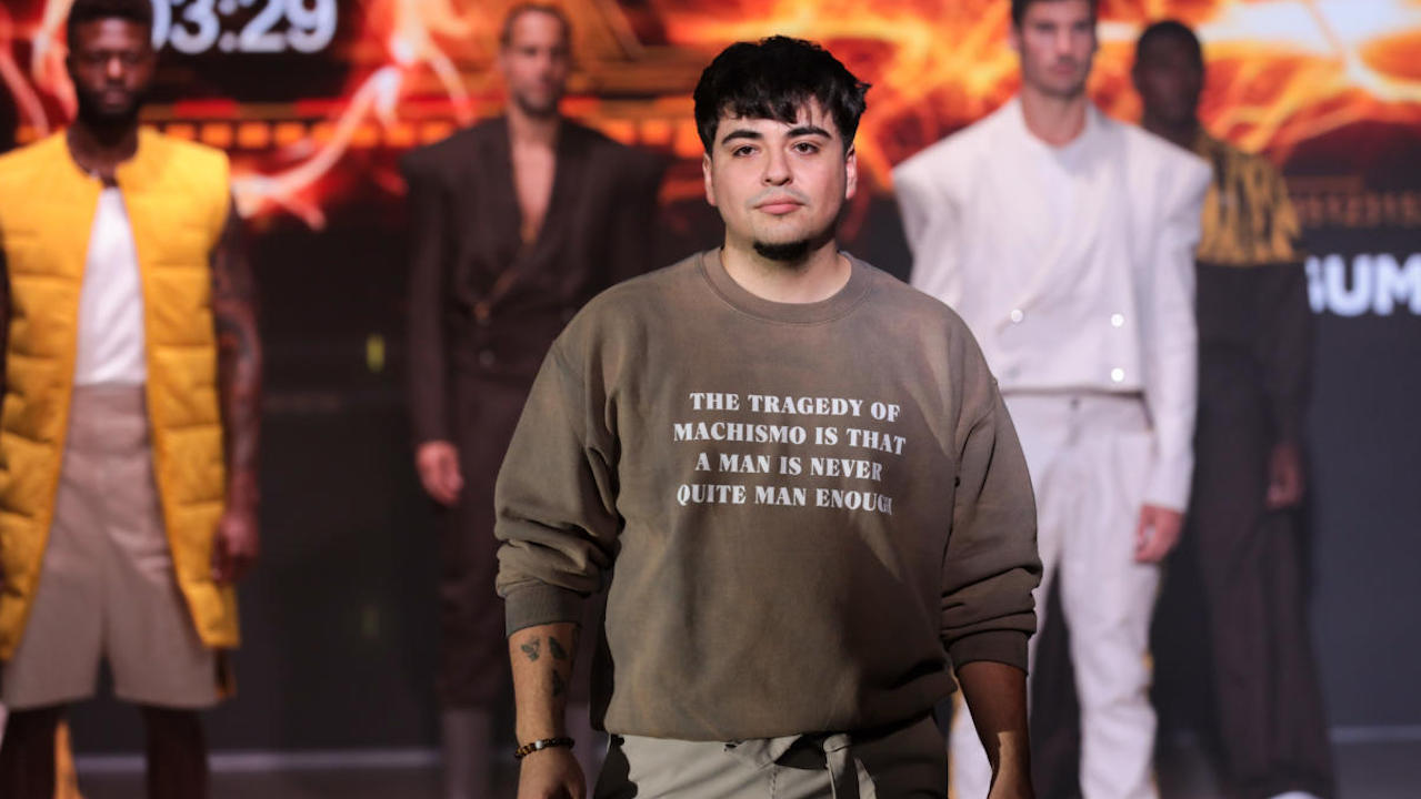 DEBUT designer Dustin Argumedo poses in front of four male models wearing his menswear designs