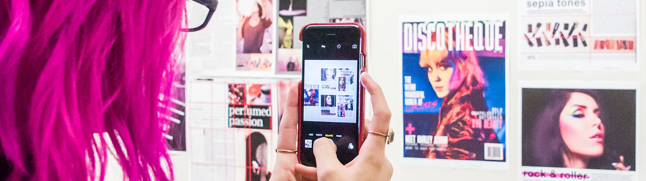 Student snaps a picture of a design display with her phone
