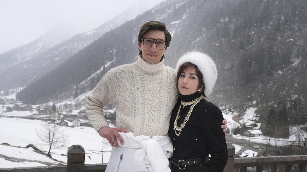 A House of Gucci film still featuring Adam Driver and Lady Gaga posed in front of snowy mountains