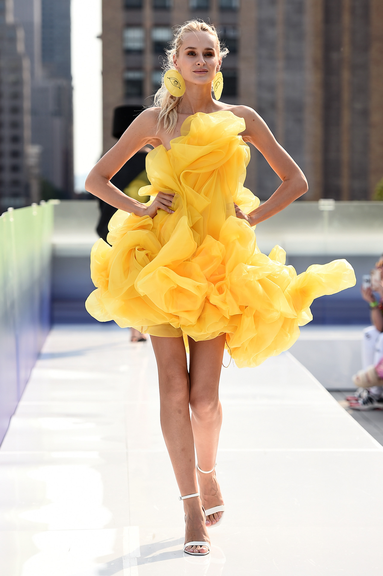 A model stands on the runway at New York Fashion Week in a yellow dress designed by FIDM Grad Kyle Denman