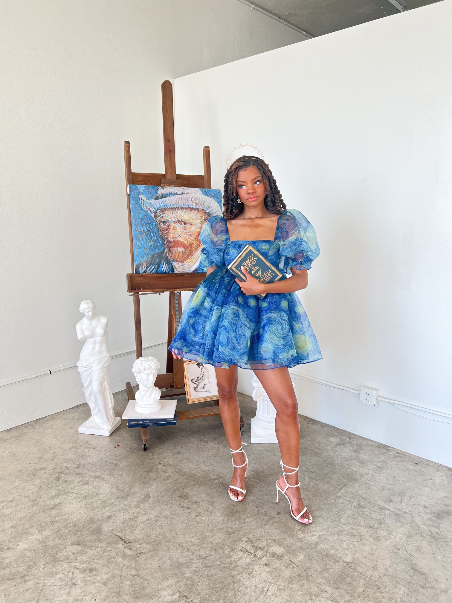 Chazlyn Stunson stands indoors next to a painting of Van Gogh