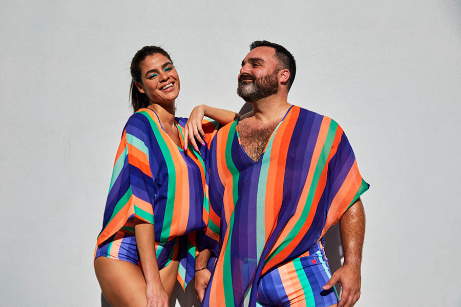 Two people wear bright printed kaftans designed by FIDM Graduate Oday Shakar