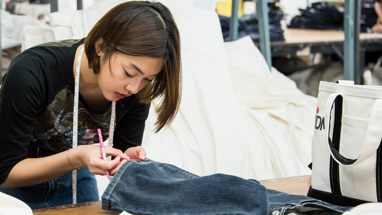Student sewing denim garment