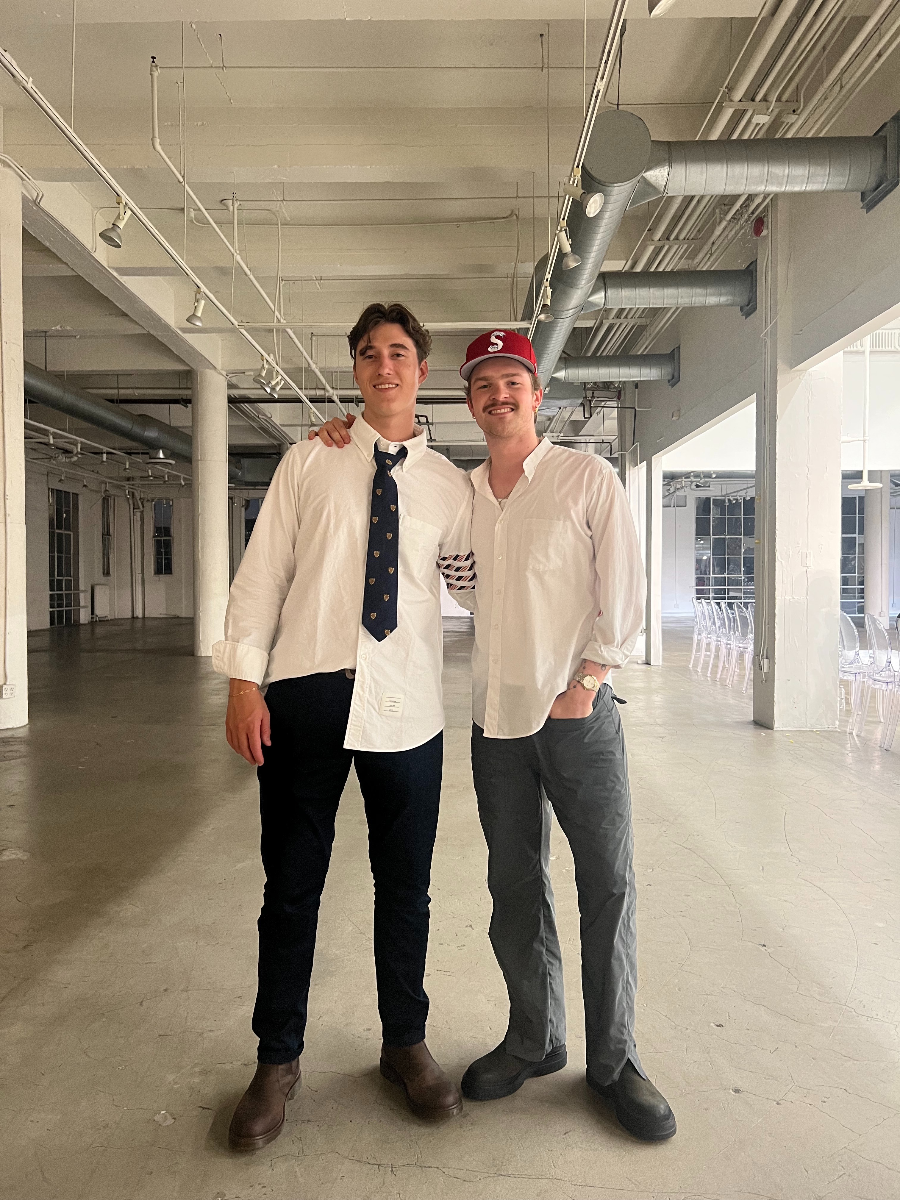 Cole Moscaret and Alexander Novak standing outside in a parking garage facing the camera
