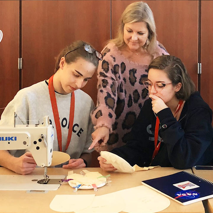 Educator Marybeth Marsh shows students how to sew
