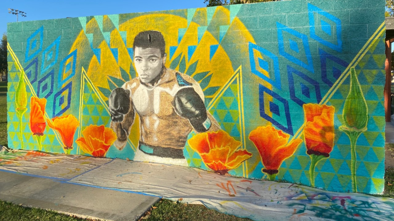 wall mural in Lancaster of Muhammad Ali holding up his hands wearing boxing gloves