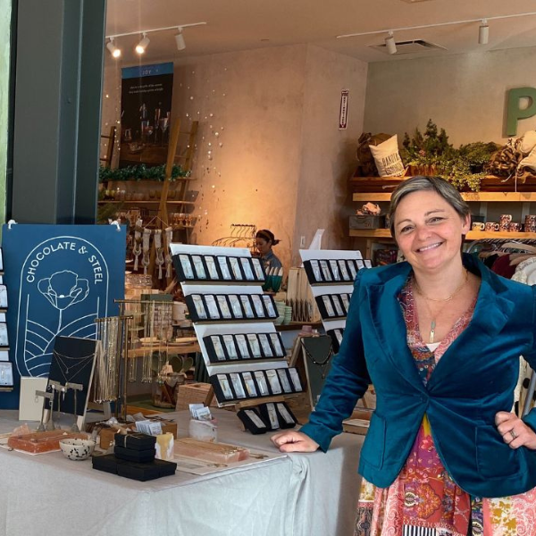 Chocolate and Steel Founder and Creative Director Christine Street stands in front of a table of her jewelry displayed at Anthropologie