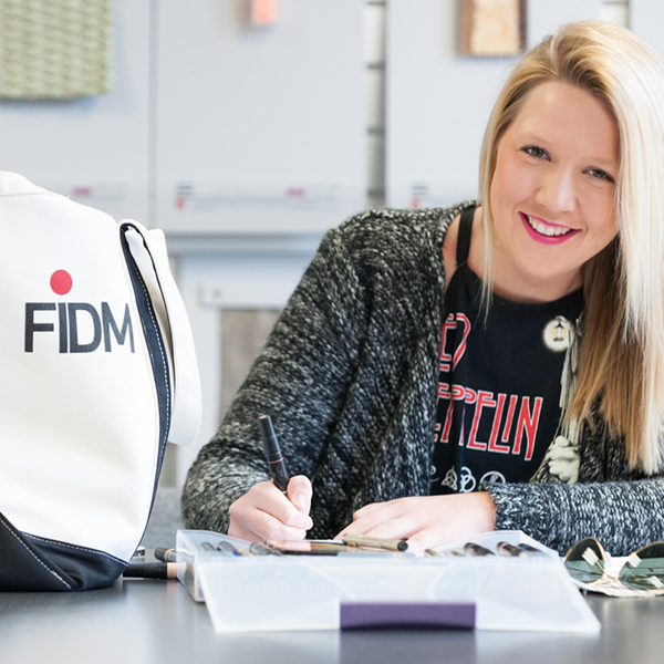 Student working at table with FIDM tote next to them