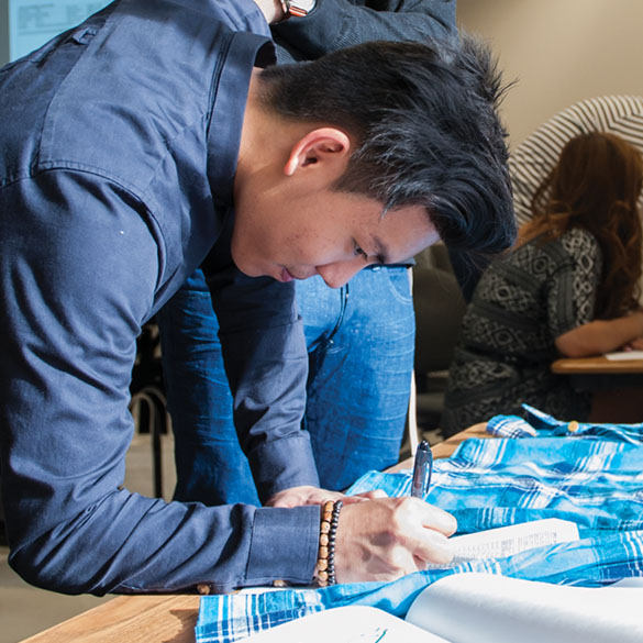 Student drawing pattern on fabric