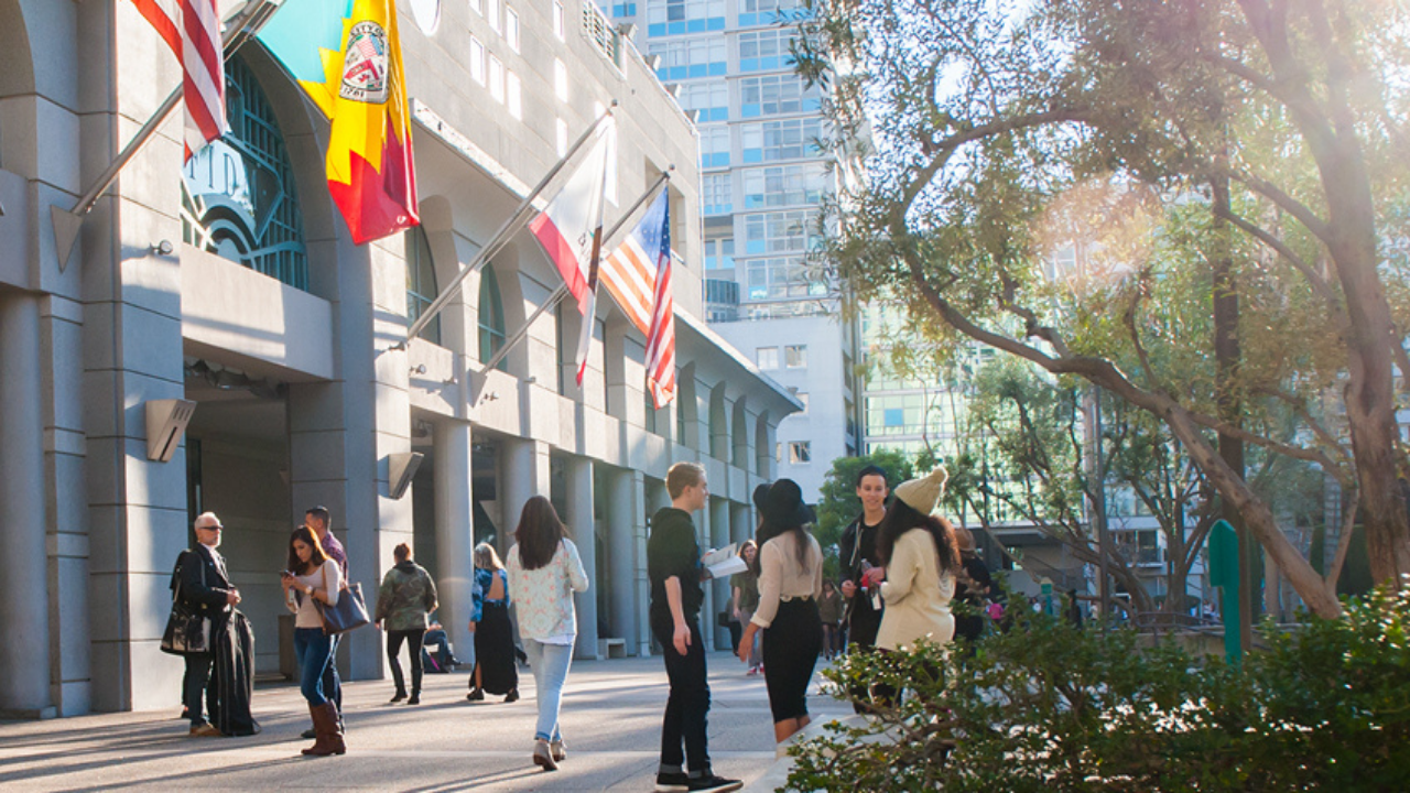 FIDM Downtown Los Angeles campus with students standing in Grand Hope Park