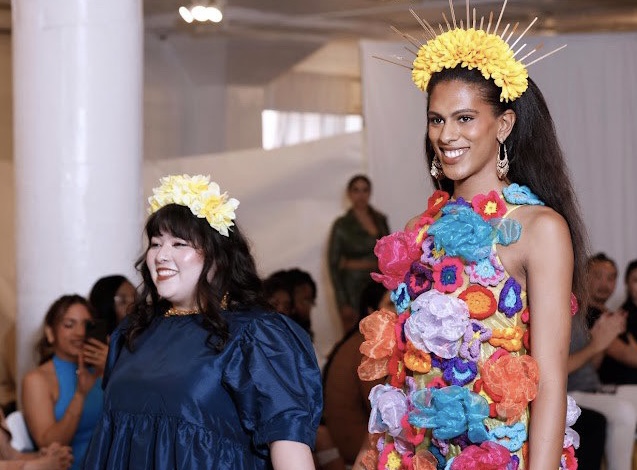Sofia Masuda fashion designer standing with model wearing one of her designs in orange, pink and yellow crocheted flowers