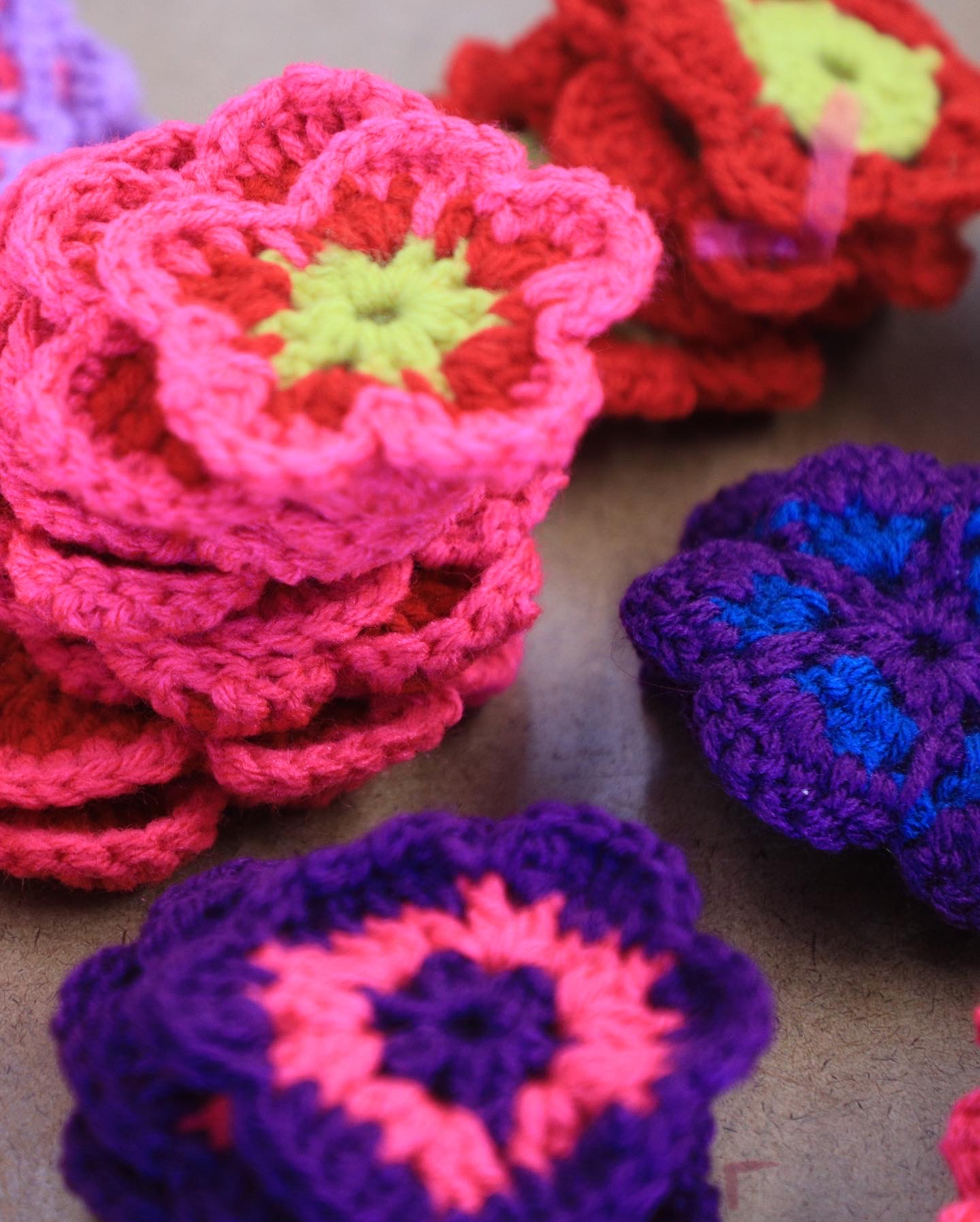 crocheted flowers designed by Sofia Masuda, in bright orange, pink, blue, and yellow
