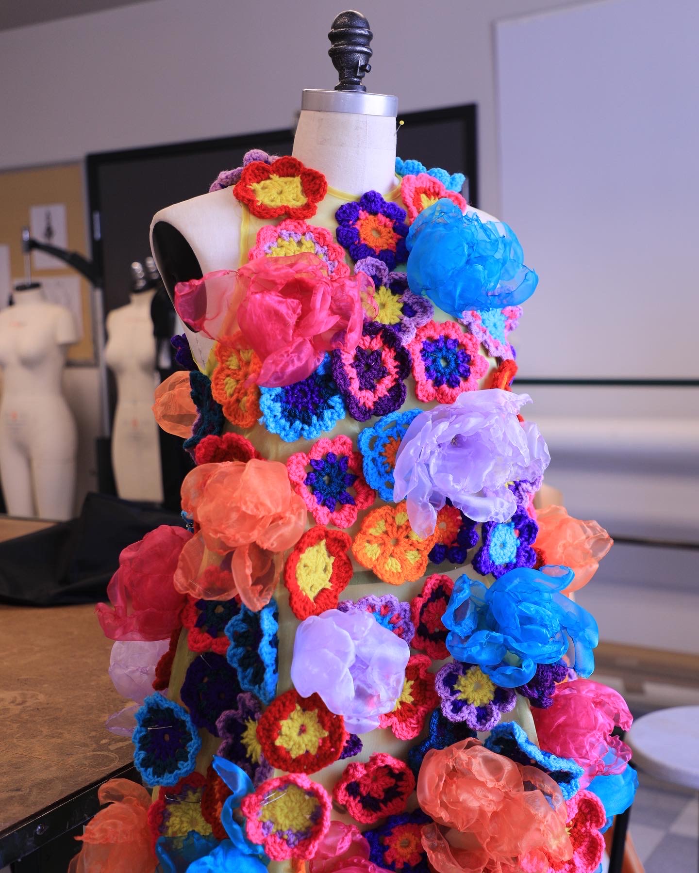 Sofia Masuda fashion design dress in bright orange, pink, blue, and yellow crocheted flowers