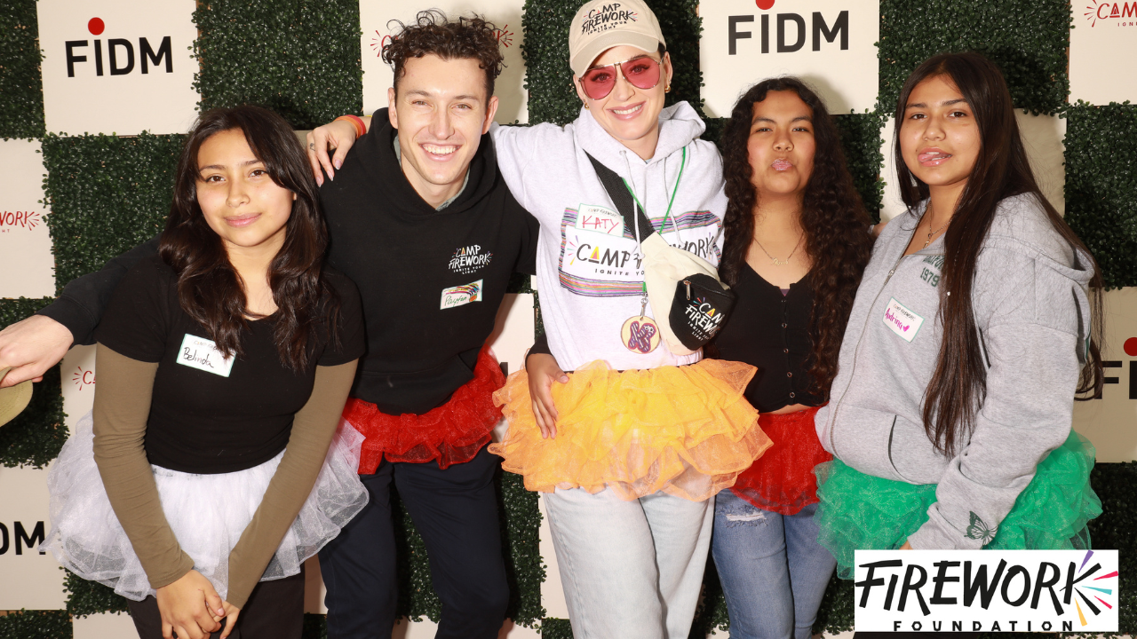 young people stand with Katy Perry against a FIDM step and repeat backdrop