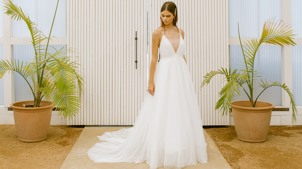 A model wears a floor length bridal gown designed Brandy Hughes