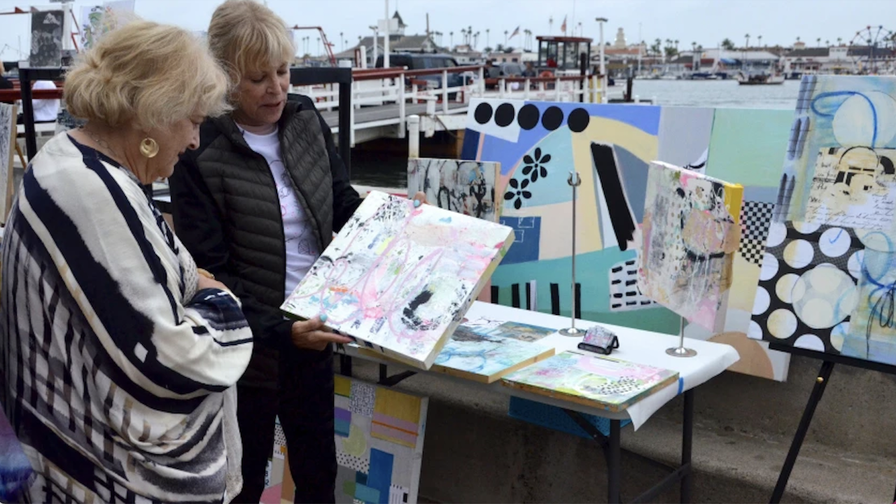 FIDM Instructor Karen Stein shows her artwork to an attendee at the Balboa Island ArtWalk