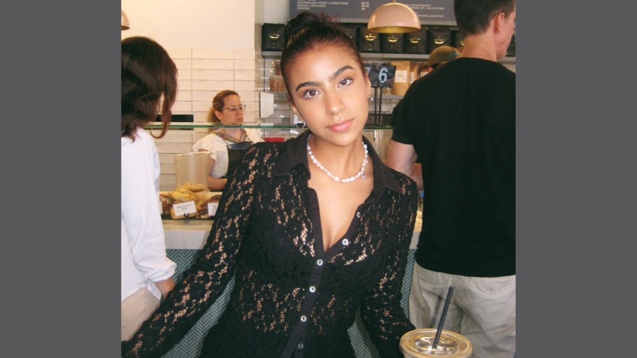 Karissa Butler wearing a black lace top indoors at a coffee shop